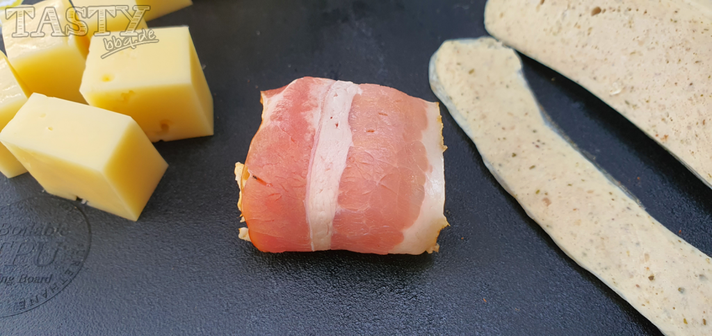 Bacon rund um den Käsewürfel wickeln.